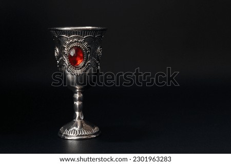 Vintage silver goblet with red wine on a black background Royalty-Free Stock Photo #2301963283