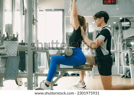sport woman exercise chest muscle with lat pull down in gym with personal trainer male take care Royalty-Free Stock Photo #2301975931