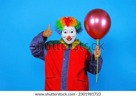colorful clown poses holding balloons on blue background
