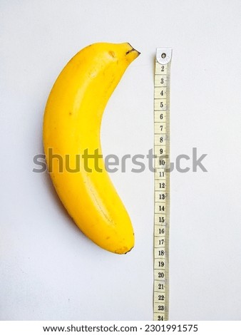 Yellow banana with measurement tape on white background. Male genitalia size concept Royalty-Free Stock Photo #2301991575