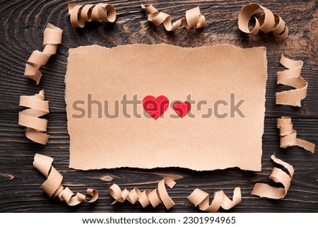 Postcard with red paper hearts. Love letter, greeting card, invitation mockup over dark wooden background. Flat lay, top view, copy space