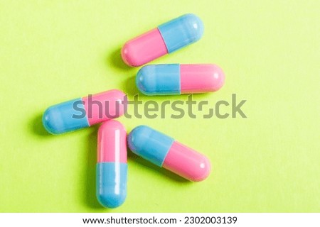 Health care concept. Top view pills on the green background, pink and blue colors. 
