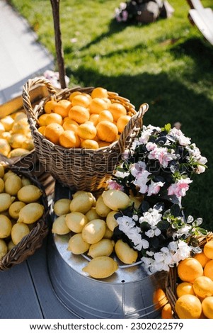 Many oranges in a wooden basket decorated with flowers
