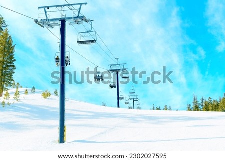 Scenic view of a chairlift and skiers at Mammoth Ski Resort. Winter sports and adventure and winter-themed designs related background. Royalty-Free Stock Photo #2302027595