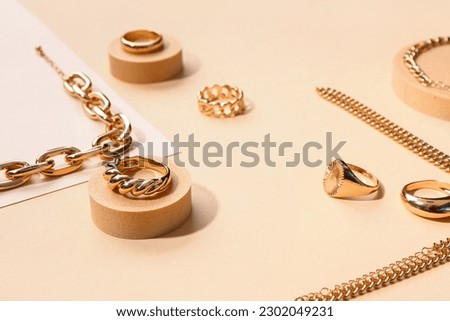 Composition with different golden rings and bracelets on color background Royalty-Free Stock Photo #2302049231