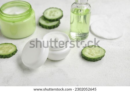 Natural cosmetics, cucumber slices and cotton pads on light table