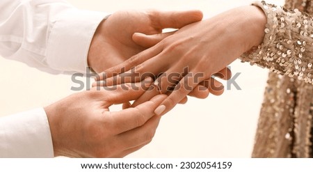 Man putting engagement ring on woman's finger, closeup Royalty-Free Stock Photo #2302054159
