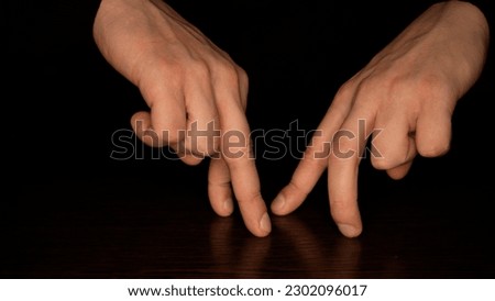 Male fingers dancing on a dark background. Fun and theater concept