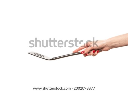 Female hand hold spatula. Isolated on a white background . High quality photo Royalty-Free Stock Photo #2302098877