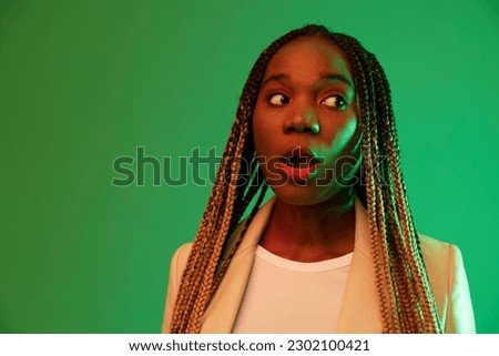 African american woman portrait business smile on green background in neon light, color mixed light, bright colors. Beauty African American woman with pigtails emotions.