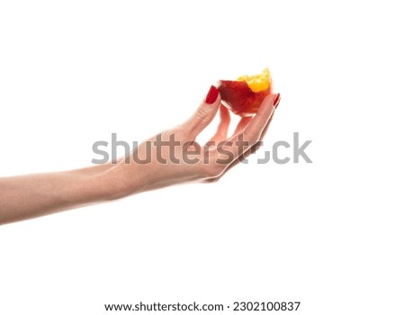 Female hand holding a nectarine, white background. High quality photo