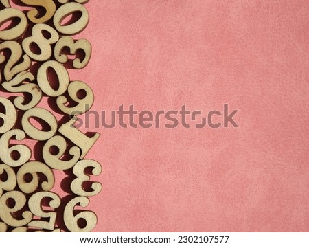 wooden numbers are randomly arranged on pink suede. High quality photo