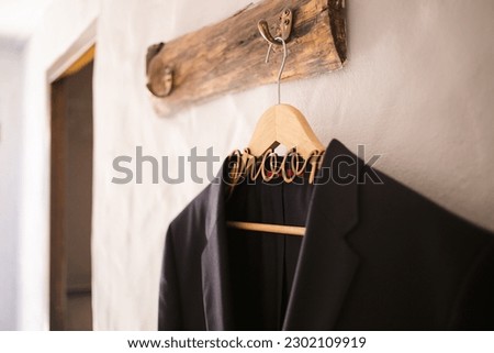 This captivating image showcases the groom's wedding attire, including his suit, shoes, and cufflinks, as he gets dressed for his big day. The photograph highlights the intricate details of the groom.