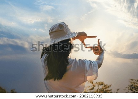 Woman Hands framing view distant over sunrise. Woman making frame round the view with her hands in sunset, Future planning idea concept. business concept. New year planning and vision concept