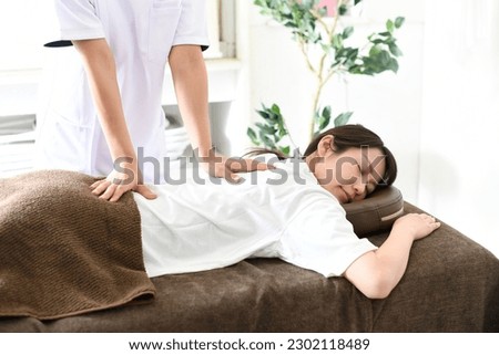 Image of a young woman receiving a surgical massage Royalty-Free Stock Photo #2302118489