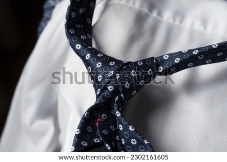 a splendid combination of a blue tie with flowers and a beautiful white shirt, elegance at weddings and important parties
