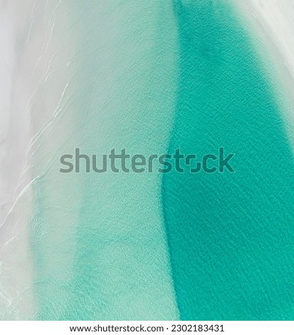 Aerial view of a beach with nice waves and shades of blues. Beautiful beach and scenes Royalty-Free Stock Photo #2302183431