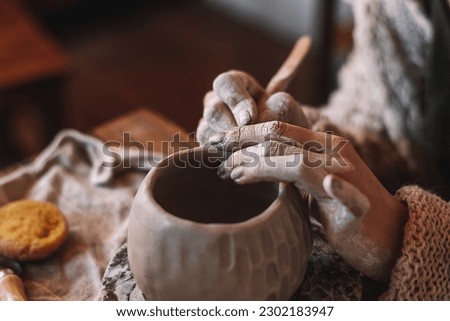 Female sculptor making clay mug in a home workshop,hands close-up.Small business,entrepreneurship,hobby, leisure concept. 