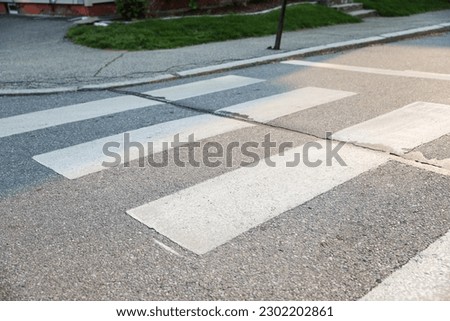Crosswalk symbolizes pedestrian safety, accessibility, and shared spaces. It represents the designated area for pedestrians to safely cross roads, promoting harmony between pedestrians and vehicles