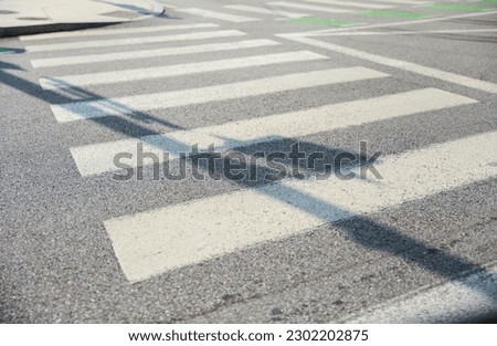 Crosswalk symbolizes pedestrian safety, accessibility, and shared spaces. It represents the designated area for pedestrians to safely cross roads, promoting harmony between pedestrians and vehicles Royalty-Free Stock Photo #2302202875