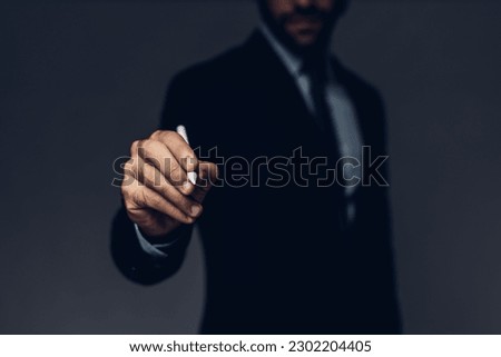 Businessman hand write something with virtual screen. Businessman holding pointing pen on virtual screen background. Man writing something in the air Royalty-Free Stock Photo #2302204405