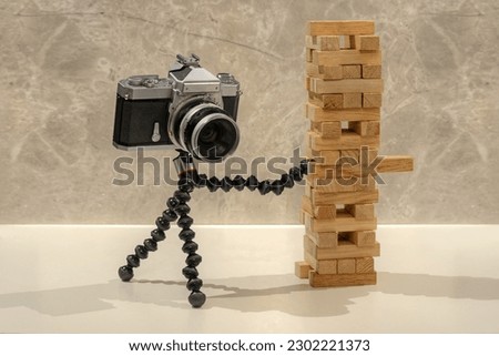 A camera playing with a wooden cub tower 