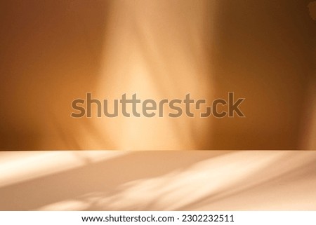White table on brown wall background. Composition with leaves shadow on the wall and light reflections. Mock up for presentation, branding products, cosmetics food or jewelry. Royalty-Free Stock Photo #2302232511
