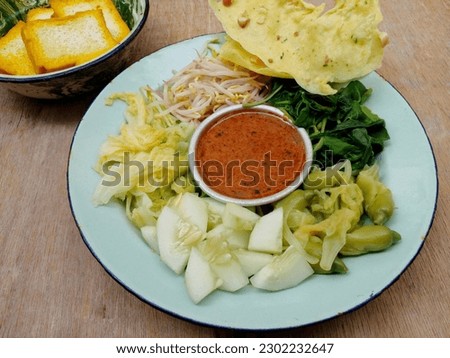 Pecel. In the form of several vegetables such as spinach, bean sprouts, cucumber, turi flowers and chicory mixed with peanut sauce. Boiled vegetables are placed on a plate. Indonesian food.
