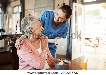 Healthcare, elderly woman with nurse with breakfast at her home and at the table in living room. Support or communication, caregiver and conversation with medical person with senior or old female.