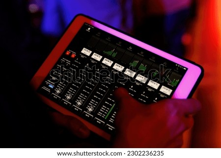 Sound technician managing concert gear with a tablet