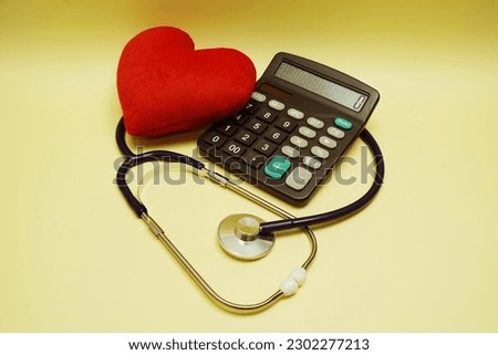 Red heart, Stethoscope and calculator on yellow background