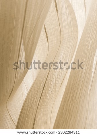 Yellowish white wavely curtain exposed to sunlight. For background. Royalty-Free Stock Photo #2302284311