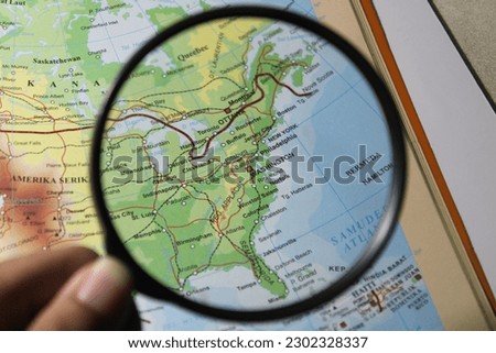 Magnifying glass on a map showing the Washington DC, capital of the USA 