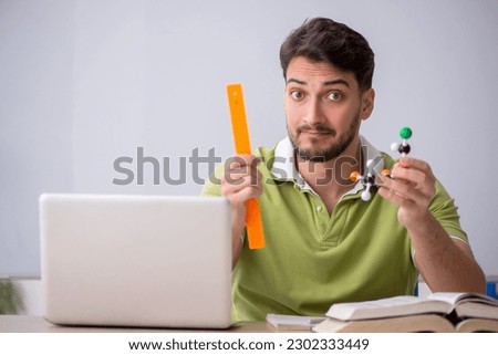 Young male student physicist sitting in the classroom Royalty-Free Stock Photo #2302333449