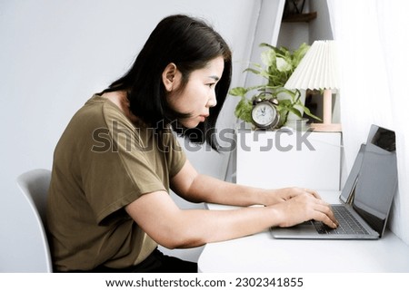 concept of Asian woman with Kyphosis: side view of laptop Work with hunched back, forward head posture, and spinal curvature Royalty-Free Stock Photo #2302341855