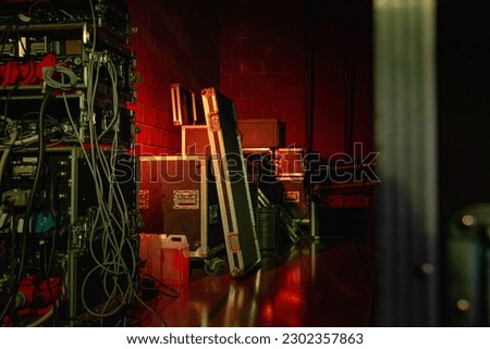Experience the electrifying anticipation of live music with this stock image. Warm, moody lighting showcases concert equipment and cases