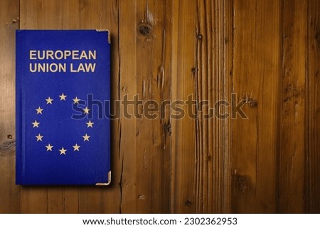 Close-up on an European Union law book with a gilded EU flag symbol in its middle. Royalty-Free Stock Photo #2302362953