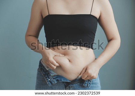 fat woman, fat belly, chubby, obese woman hand holding excessive belly fat with measure tape, woman diet lifestyle concept Royalty-Free Stock Photo #2302372539