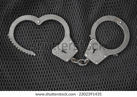 Handcuffs, manacles, bracelets, ruffle. Handcuffs on a black background. Metal shackles isolated. Law. Limitation. Freedom. Security. Police bracelets.