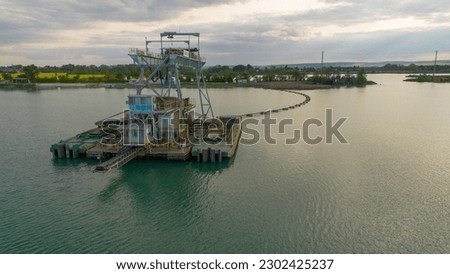 Industrial boat floating on the lake. Boat in the middle of the lake. Water background. Boat from mining industry. 
