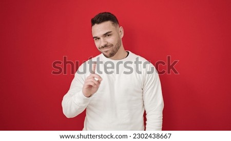 Young hispanic man smiling confident saying no with finger over isolated red background Royalty-Free Stock Photo #2302438667