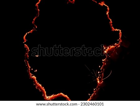 burning paper, glowing edge of paper on a black background Royalty-Free Stock Photo #2302460101