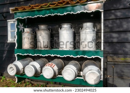 Rack with classic milk cans on a traditional farm in Netherlands