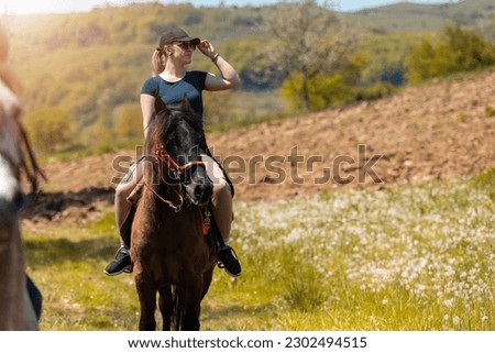 A girl with glasses on a horse looks into the distance