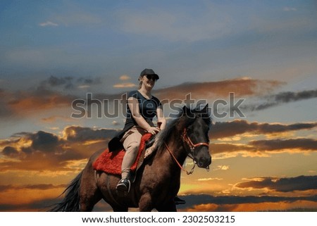 A girl rides a horse at sunset