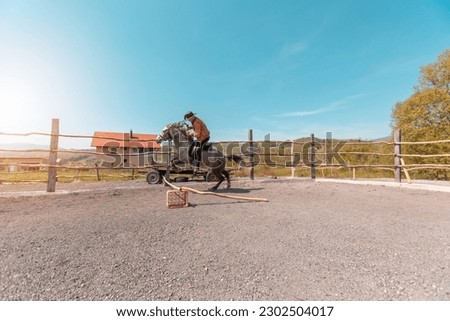A cowboy smashes an obstacle with a white horse