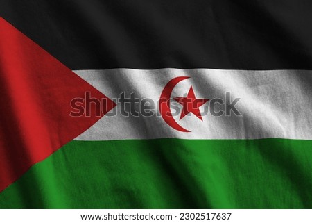 Western Sahara flag with big folds waving close up under the studio light indoors. The official symbols and colors in fabric banner