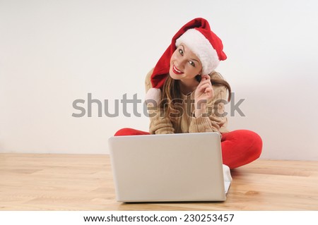 beautiful young woman in santa hat searching online presents for Christmas or New Year holiday on white background