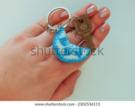 Bead colorful key chain in a female hand. Bright key chain lies on a woman's palm