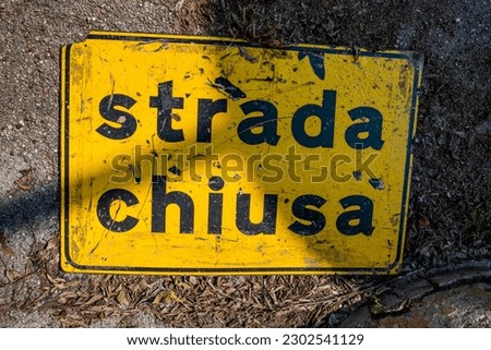 yellow sign and black outline with road closed written abandoned on land